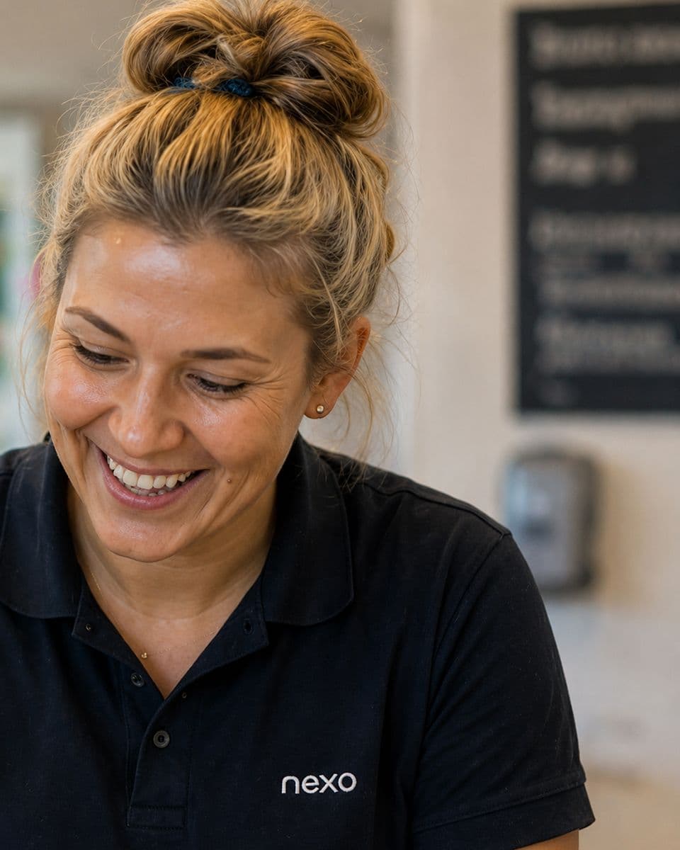 Smiling Nexo care worker in a navy uniform